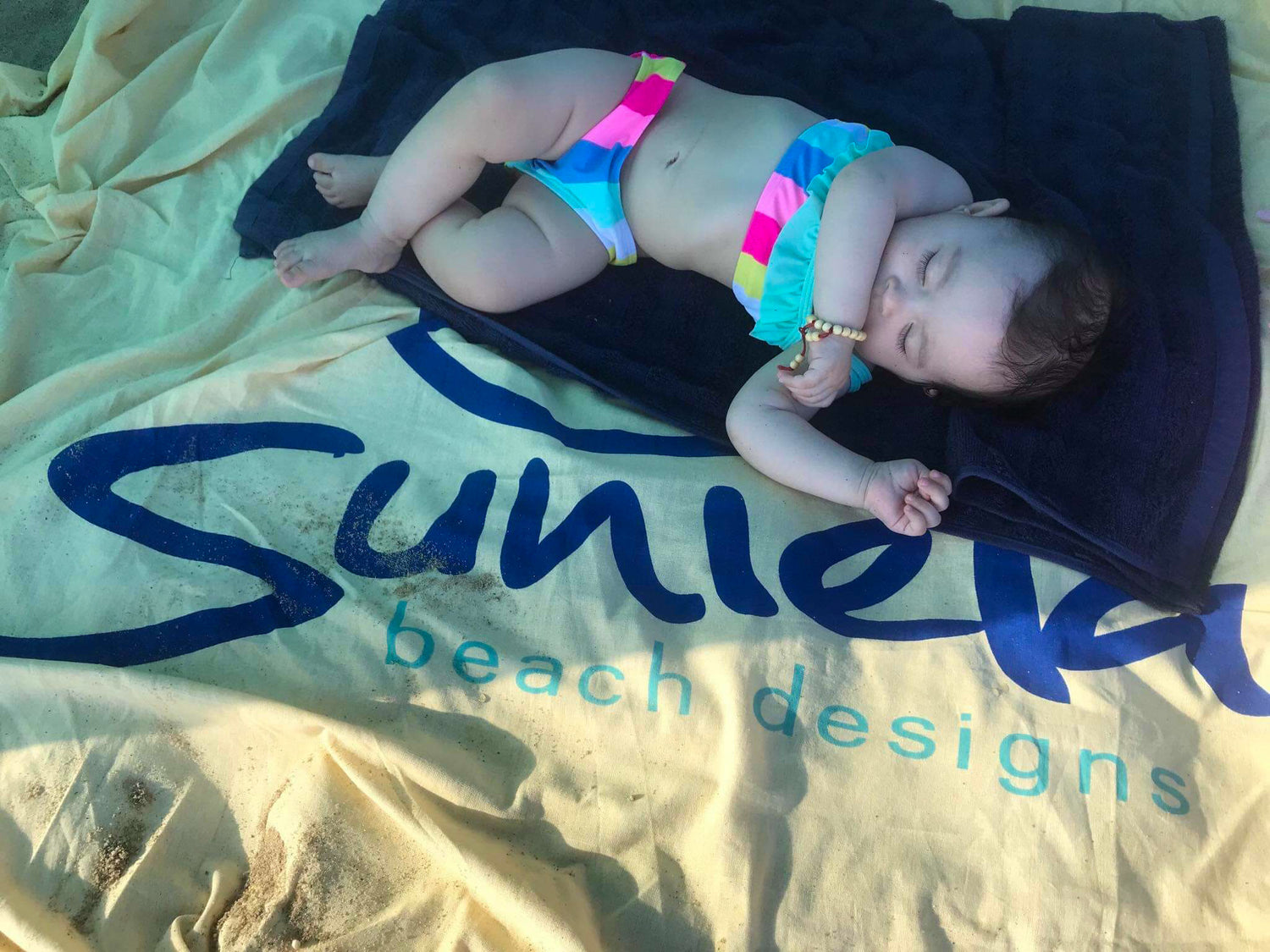 Baby sleeping in the shade of beach shelter by Suniela