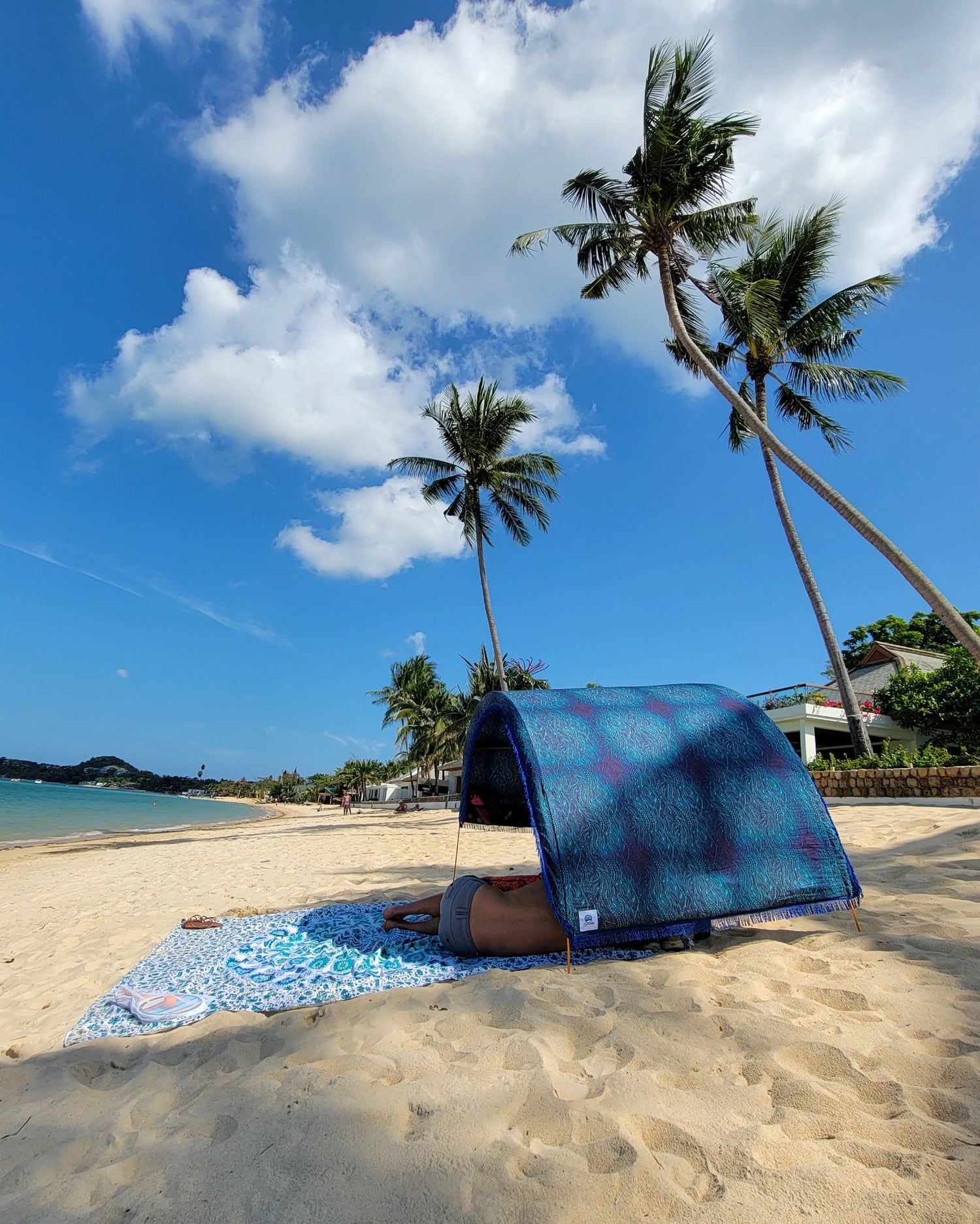 Suniela portable beach cabana with Ocean Waves cotton canopy providing shade on a sandy beach