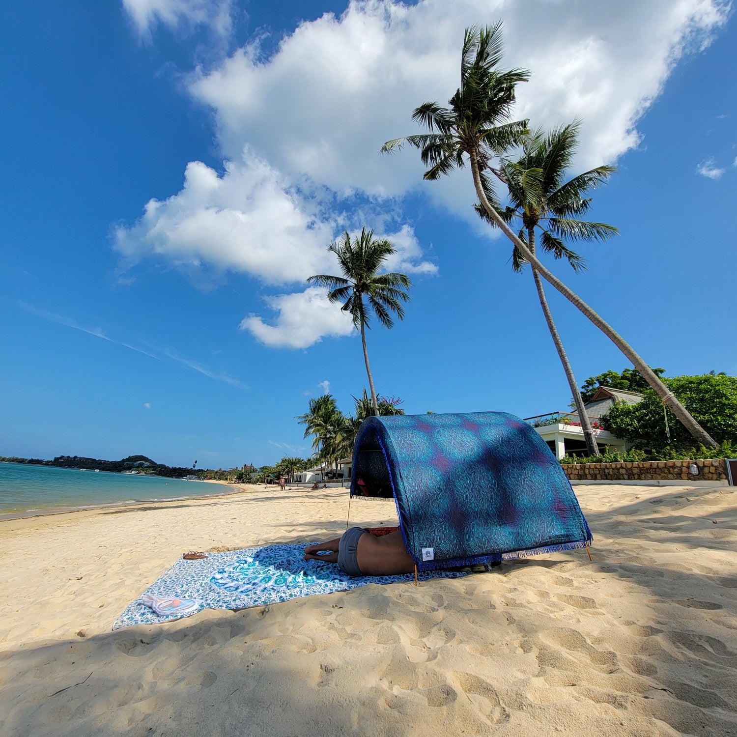 Suniela portable beach cabana with Ocean Waves cotton canopy providing shade on a sandy beach