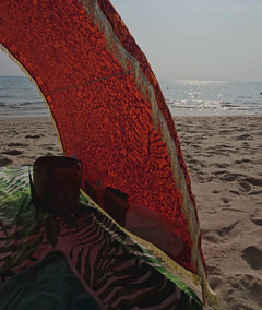 video showing details like pockets full of accessories , fringes and tribal jungle  pattern on a Suniela shade cabana on a sandy beach