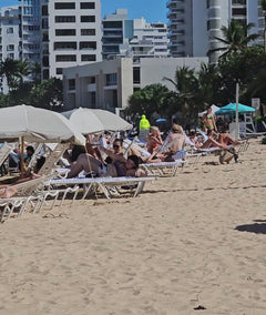 panoramic video of a crowded beach with loungers and parasols everywhere, and a lone Suniela shade in turquoise colour standing out from the rest. 