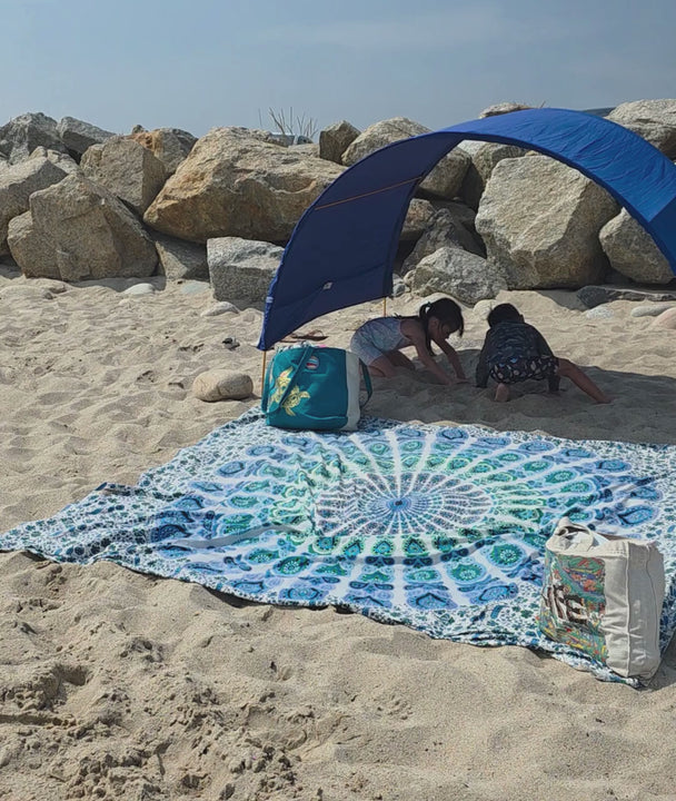 kids playing in the sand in the shade beneath their blue Suniela shade tent