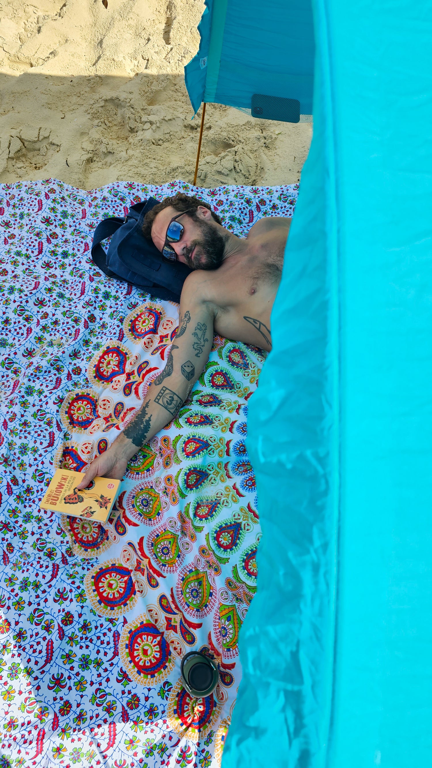 man napping on Suniela giant cotton beach mat 